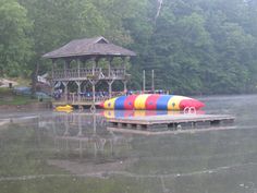 there is a large colorful boat on the water in front of a dock with a life guard tower