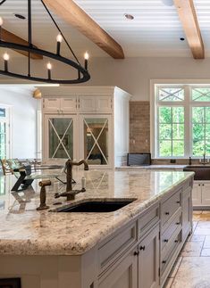 a large kitchen with marble counter tops and white cabinets