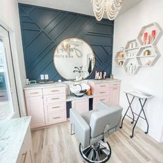 a room with a chair, mirror and chandelier on the wall in front of it