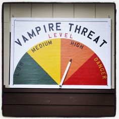 a sign that is on the side of a building saying, vampire threat level high