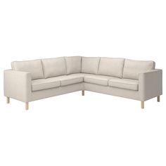 a white sectional couch sitting on top of a wooden floor next to a white wall