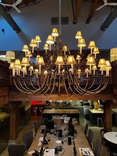 a large chandelier hanging from the ceiling in a room with tables and chairs