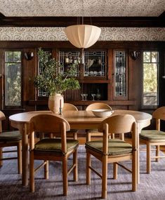 a dining room table with chairs and a potted plant in the center on top of it