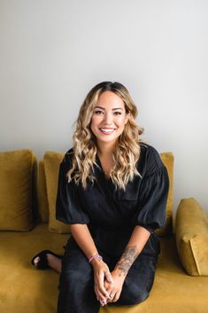 a woman sitting on top of a yellow couch