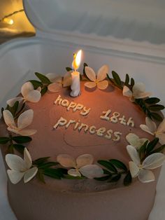 a birthday cake decorated with flowers and a lit candle