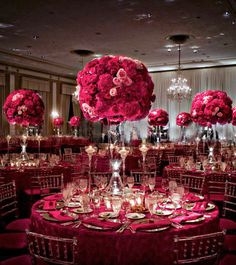 the tables are set up with red flowers and candles for an elegant dinner or party