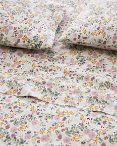 an image of a bed with floral sheets and pillowcases on top of it