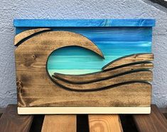 a wooden sign with a wave painted on it