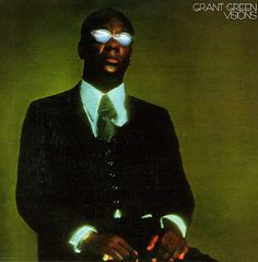 a man in a suit and tie with sunglasses on his head, holding a record