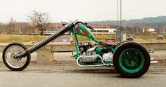 a green and black motorcycle parked on the side of a road