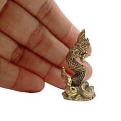 a small gold figurine in the shape of a dragon sitting on a rock