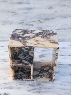 marble side table with two shelves on top and one shelf in the shape of a cube