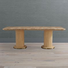 a large wooden table sitting on top of a hard wood floor next to a gray wall