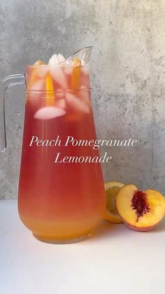 peach pomegranate lemonade in a pitcher with ice and sliced peaches