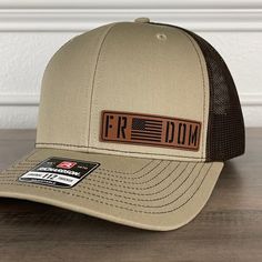 Freedom American Flag Patriotic Leather Patch Hat Khaki/Brown. Specifications: 🧢 Richardson original 112 trucker; adjustable for the perfect fit 🎩 60/40 cotton/polyester blend for comfort 📏 One size fits most 🏷️ Expertly laser engraved leatherette patch design 📦 Ships in 2 to 3 business days from our Orlando Studio Care Instructions: 🚫 Do not wash; spot clean only Please Note: 🌈 Colors may vary from photos based on your viewing screen. Leather Patch Hat Ideas, Creek Ideas, Orlando Studios, Funny Trucker Hat, Carhartt Sweatshirts, Hat Bar, Leather Patch Hat, American Flag Hat, Wood Burn Designs