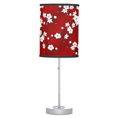 a red lamp with white flowers on it