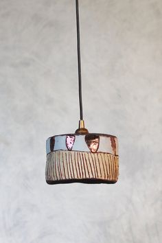 a light hanging from a ceiling in the shape of a boat with hearts on it