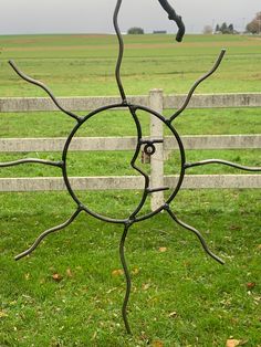 a metal sculpture sitting on top of a lush green field