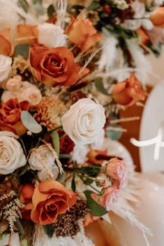 an arrangement of flowers and feathers on a table