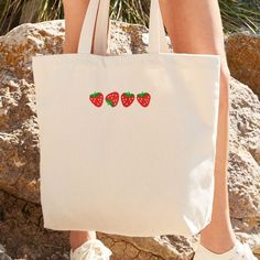 Strawberry Embroidered Tote Bag, Cute Fruit Bag, Strawberry Gift, Embroidered Gift for Friend, Cosy Cottage Core Shoulderbag, Strawberries  PRODUCT SPECIFICATIONS: - Recycled Cotton/Polyester blend - 270gsm - Made from a blend of pre-consumer recycled cotton and postconsumer recycled polyester - Weight: 8.0 oz/sq yd - Recycled Polyester made from 100% rPET, equivalent to approx. 3.5 post-consumer bottles - Dimensions: 35 x 39 x 13.5cm - Handle Length: 58cm DISCLAIMER: 👉 Colours may differ sligh Fruit Tote Bag, Fruit Bag, Strawberry Gifts, Cosy Cottage, Embroidered Tote Bag, Embroidered Tote, Embroidered Gifts, Cute Fruit, Bag Cute