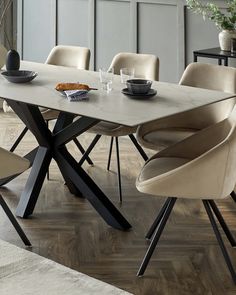 a dining table with chairs around it and a vase on the table next to it