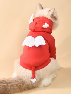 a cat wearing a red hoodie with white angel wings on it's back