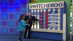 a man and woman standing in front of a sign with numbers on it that says switcheroo