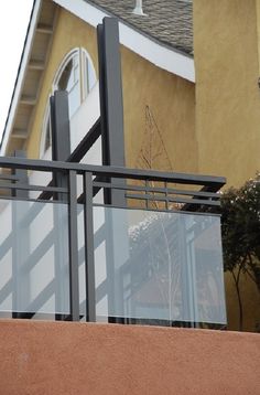 a cat sitting on top of a metal railing next to a building