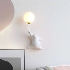 there is a white polar bear on the wall with a light in it's hand