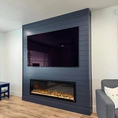 a living room with a fireplace and television mounted on the wall