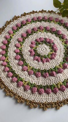 a crocheted rug with pink flowers on it