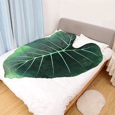 a bed with a large green leaf on it