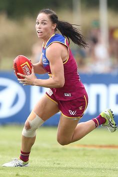 a woman running with a football in her hand