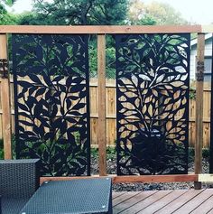 a wooden deck with two chairs and an iron screen