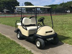 a golf cart is parked on the side of the road in front of some grass