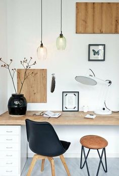 a desk with two chairs and some pictures on the wall