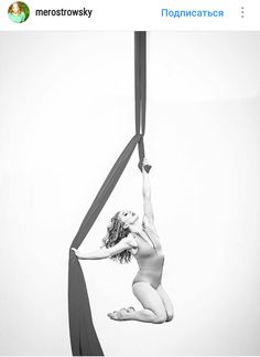 a woman is performing aerial acrobatics on a pole in black and white