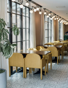 an empty restaurant with yellow chairs and tables