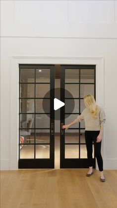 a woman standing in front of an open glass door