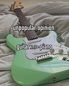 an electric guitar sitting on top of a bed with the caption unpopular opinion guitar > > > piano