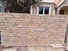 a brick wall in front of a house with no doors and windows on the side