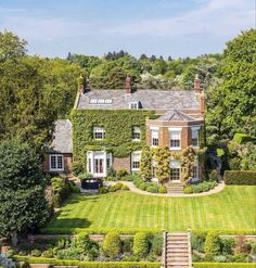 an aerial view of a large house surrounded by trees and bushes with stairs leading up to the front door