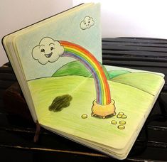 two children's books on top of a piano with a drawing of a rainbow