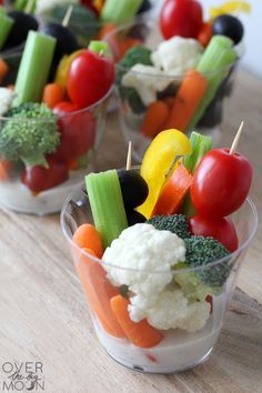 small cups filled with veggies on top of a wooden table