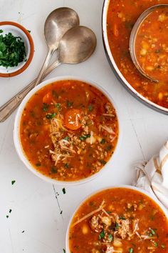 two bowls of soup on a table with spoons