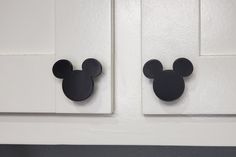 two mickey mouse magnets on the front of a white door