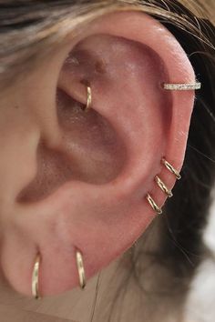 a close up of a person's ear with three different piercings on it