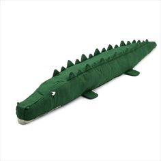 a stuffed alligator is laying on the ground