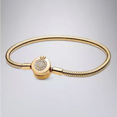 a gold bracelet with a diamond clasp on the end and a small round bead in the middle