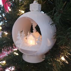 a white ornament hanging from a christmas tree